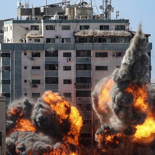 TOPSHOT - A ball of fire erupts from the Jala Tower as it is destroyed in an Israeli airstrike in Gaza City, controlled by the Palestinian Hamas movement, on May 15, 2021. - Israeli air strikes pounded the Gaza Strip, killing 10 members of an extended family and demolishing a key media building, while Palestinian militants launched rockets in return amid violence in the West Bank. Israel's air force targeted the 13-floor Jala Tower housing Qatar-based Al-Jazeera television and the Associated Press news agency. (Photo by Mahmud Hams / AFP) (Photo by MAHMUD HAMS/AFP via Getty Images)